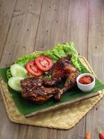 Delicious freshly baked crispy baked chicken is appetizing served on a wooden dish photo