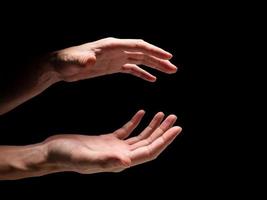 Male hands on a black background. photo