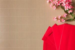 vista superior de flores de ciruelo chino y paquetes rojos sobre la mesa, concepto de año nuevo chino, espacio libre para texto foto