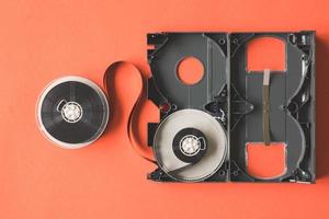 Open video cassette tape on orange background. photo