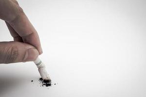 A hand push the cigarette stub on white background, Symbolic stop smoking concept, Free space for text photo