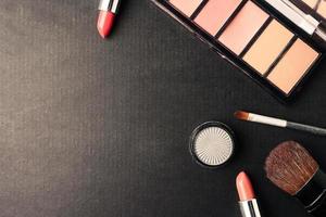 Top view of cosmetics set for makeup on a black background. Free space for text. photo