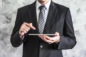 Close up of businessman using tablet device on grunge background. photo