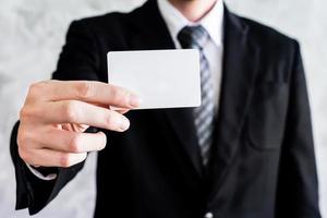 Close up of businessman holding white blank card on grunge background. photo