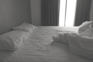 sábanas y almohadas blancas desordenadas. tono blanco y negro foto