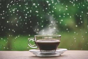 Cup of coffee on the table inside the window, coffee break in the morning with rainy day, relaxing and refreshing concepts. photo