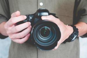 el primer plano de un hombre casual sostiene una cámara, concepto de fotografía. foto