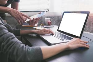 socios comerciales que trabajan juntos en el escritorio de la oficina, están usando una computadora portátil con pantalla en blanco y tableta.