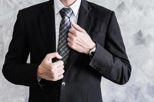 Close up of businessman in black suit on grunge background. photo