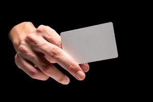 Male hand holding card on a black background. photo