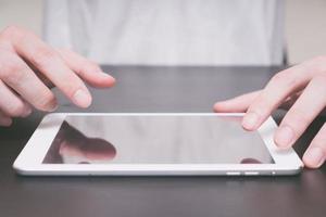 Close up of Male hands using tablet on the table. photo