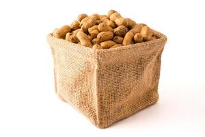 Peanuts in burlap bag on white background. photo