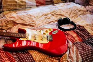 Electric guitar and headphones in bedroom, Films grain filter. photo
