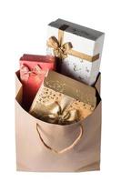 Gift boxes in brown paper bag on white background. photo