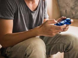 Close up of a young gamer playing the video game with a joystick. photo