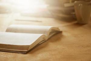 Close up of open notebook on wooden desk, Soft focus,  Flare sun light,Vintage tone. photo
