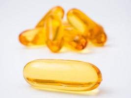 Fish oil capsules on a white background, Vitamin D supplement, selective focus photo