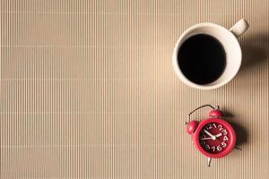 Top view of coffee cup with clock on table. Free space for text photo