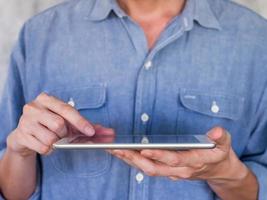 primer plano de un hombre casual usando una tableta, concepto de comunicación foto