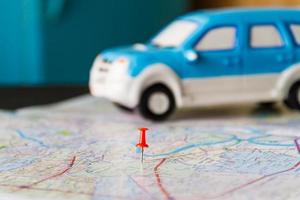 Toy car and push pin on the map. Travelling concept. Shallow depth of field. photo