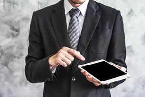 Close up of businessman holding tablet device on grunge background. photo