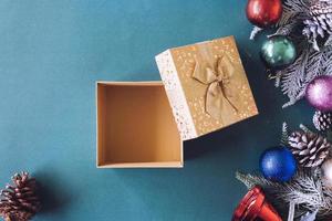Empty golden gift box with Christmas decoration on green background. photo