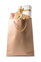 Gift boxes in brown paper bag on white background. photo