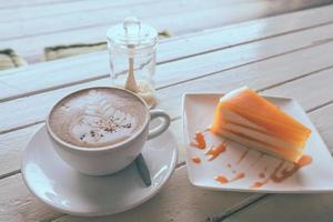 Coffee and orange cake on wooden table. Vinge tone photo