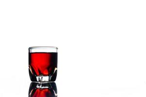 Glass of alcohol on a white background. Free space for text photo