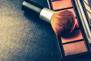 Makeup brush and palette on black background, Vintage tone, Free space for text. photo