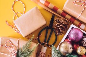 Preparation gifts with Christmas decorations on a yellow background.