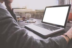 Close up of Casual young woman using a laptop with blank screen on the desk. Vintage tone photo