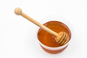 Honey with wood stick on white background. photo