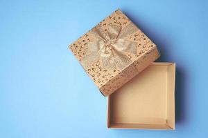 Top view of open gift box on blue background. Free space for text photo