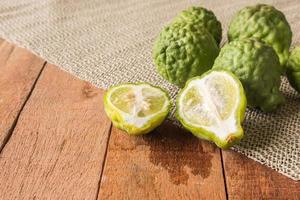Close up of bergamot or kaffir lime on wooden table background. photo
