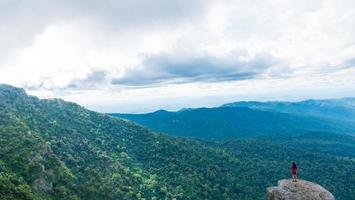 Young woman enjoying a valley view from top of a mountain. photo