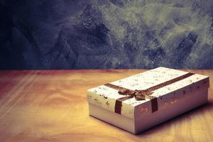 White gift box on the wooden table. Free space for text photo
