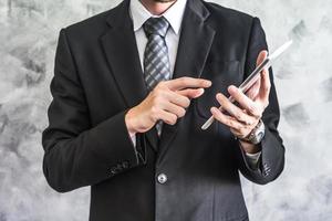 Close up of businessman using tablet device on grunge background. photo