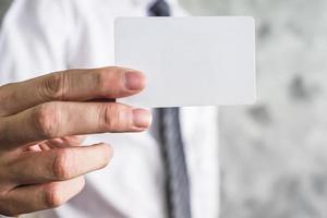Close up of businessman holding white blank card on grunge background. photo