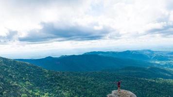 Young woman enjoying a valley view from top of a mountain. photo