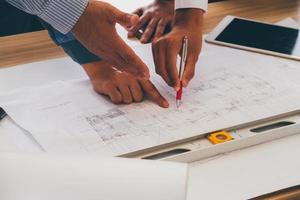 equipo de ingenieros discutiendo el boceto del plan de arquitectura en el sitio de construcción. foto