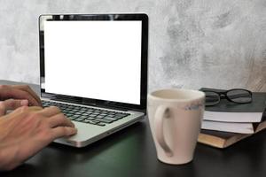 Close up of male hands using laptop with white screen monitor on the desk. photo