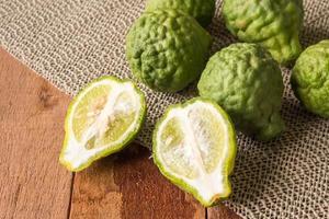 Close up of bergamot or kaffir lime on wooden table background. photo