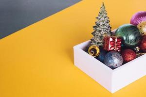 Christmas decorations in white box on colorful background. photo