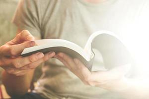 Close up of male hands holding a book to read, Flare from the sunlight photo