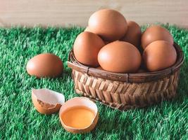 Eggs in wooden basket on green grass. Selective focus photo