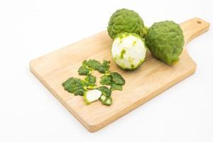 Sliced skin bergamot or kaffir lime on wooden tray over white background. photo