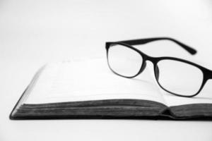anteojos en un libro abierto, tono blanco y negro foto