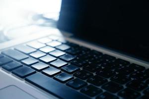 Close up of laptop keyboard with sunlight. selective focus photo