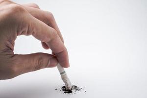 A hand push the cigarette stub on white background, Symbolic stop smoking concept, Free space for text photo